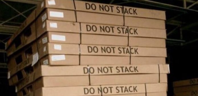 Work instructions apparently unclear. A bunch of pallets stacked together, despite "DO NOT STACK" clearly written on them.