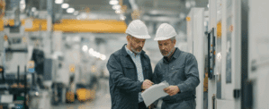 Two factory workers looking at a SOP