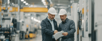 Two factory workers looking at a SOP